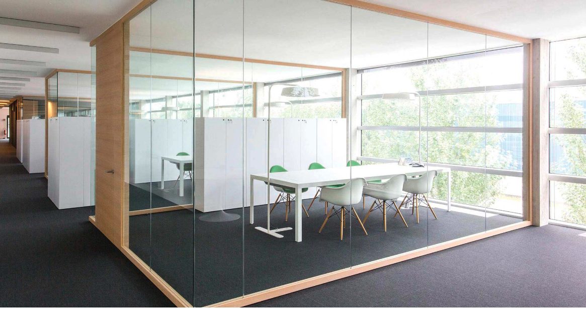 Adotta glass walled meeting room with wooden accents and forest views
